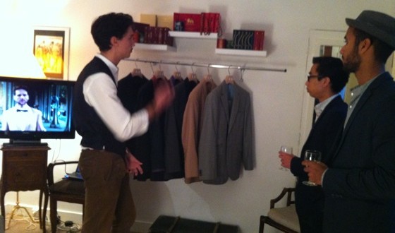Présentation de la marque Monsieur Bartok : des costumes sur portant dans un showroom, devant deux visiteurs.